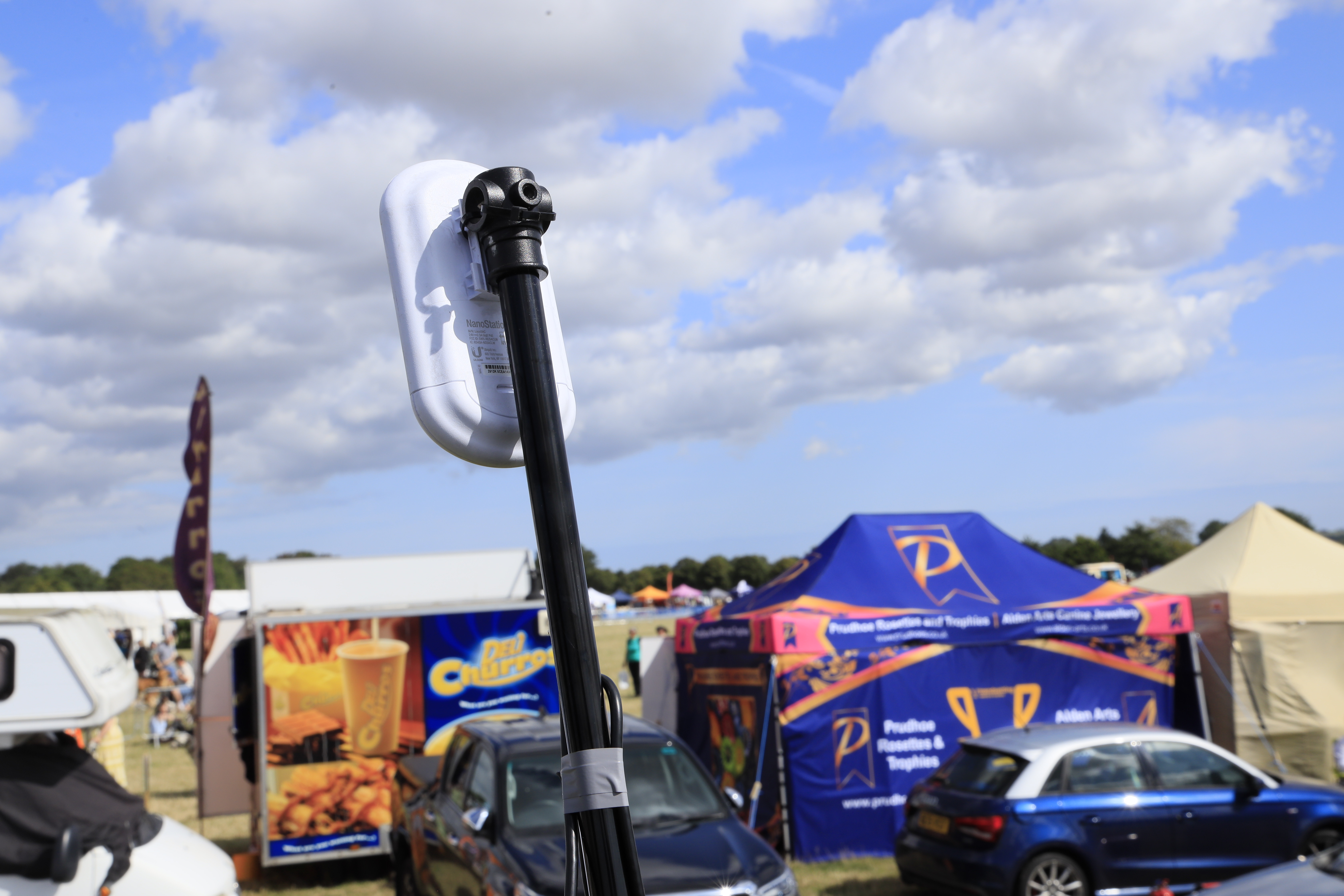 Wireless link on a pole beside branded activation stands